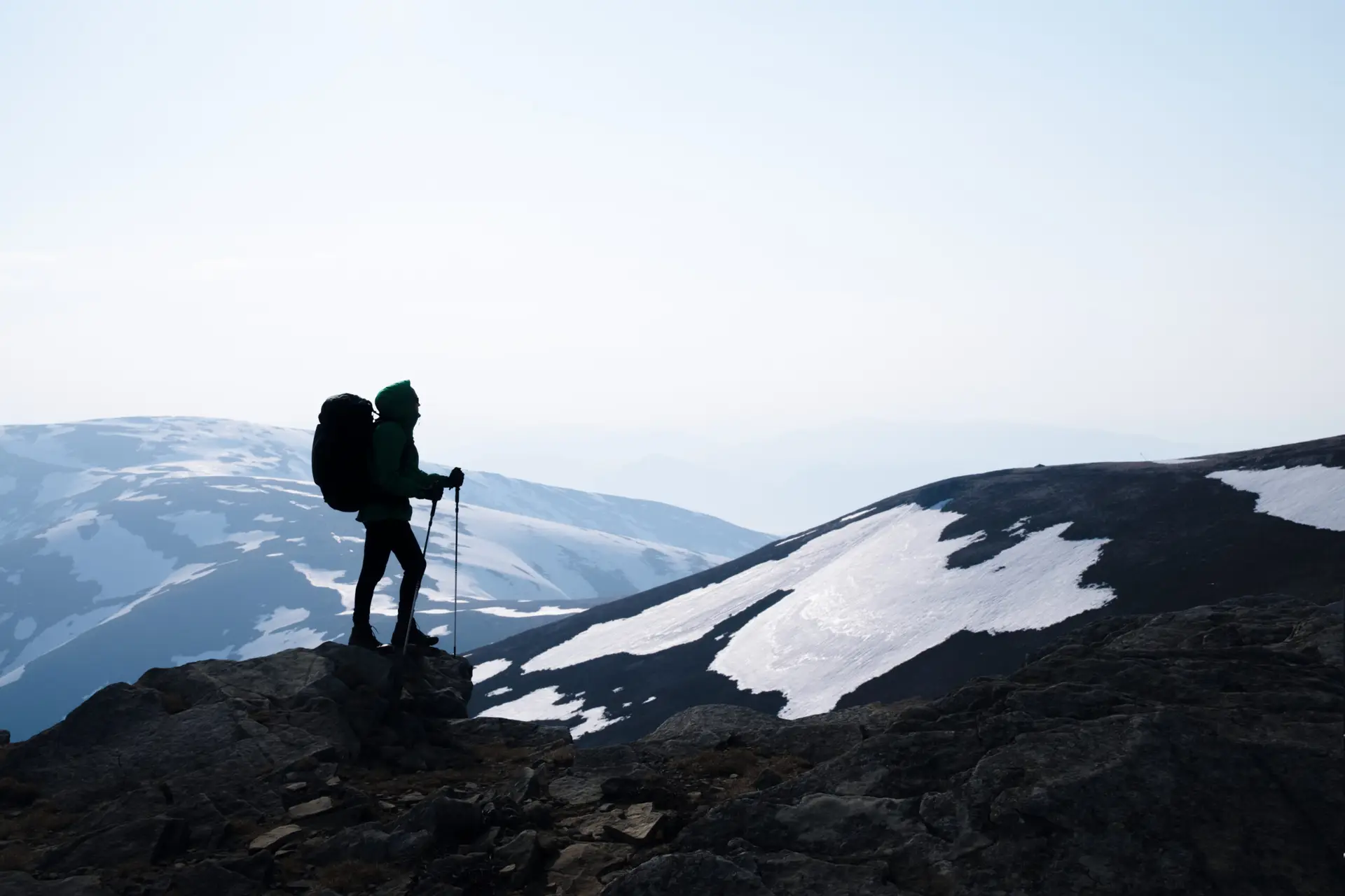 Wanderer mit Rucksack vor schneebedeckten Bergen